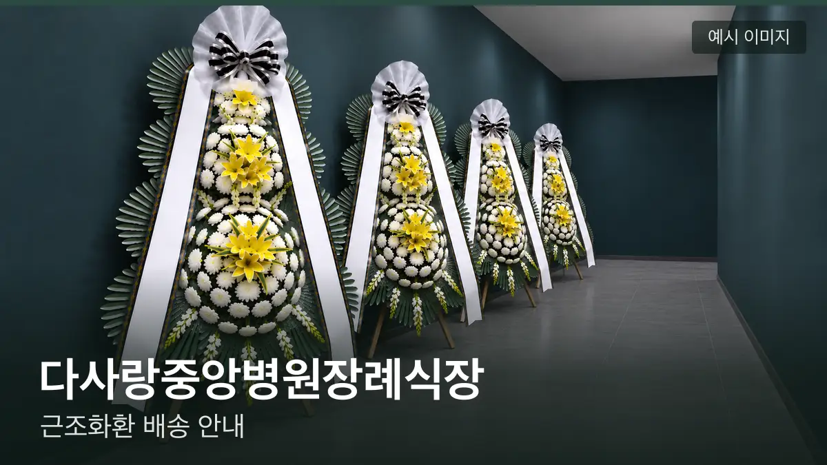 다사랑중앙병원장례식장 근조화환 예시 이미지 — 흰 국화 3단 근조화환이 벽을 따라 나란히 놓인 모습