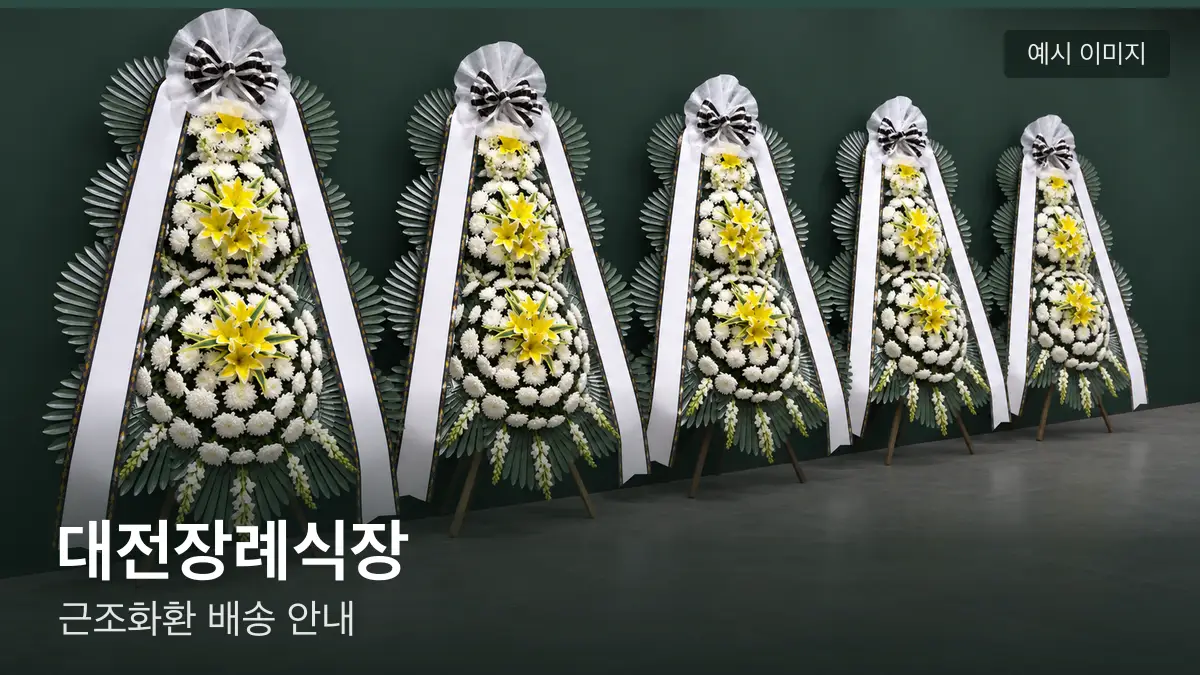 대전장례식장 근조화환 예시 이미지 — 흰 국화 3단 근조화환이 벽을 따라 나란히 놓인 모습