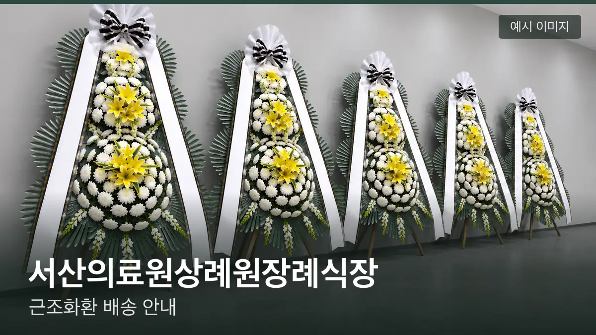 서산의료원상례원장례식장 근조화환 예시 이미지 — 흰 국화 3단 근조화환이 벽을 따라 나란히 놓인 모습