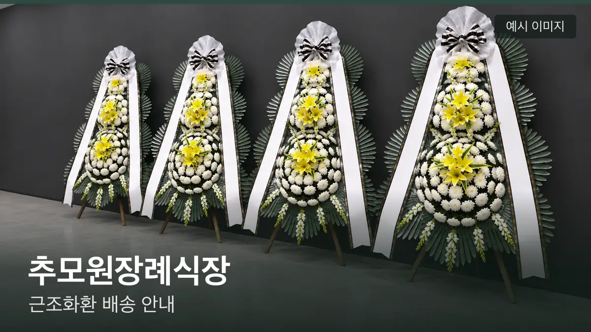 추모원장례식장 근조화환 예시 이미지 — 흰 국화 3단 근조화환이 벽을 따라 나란히 놓인 모습