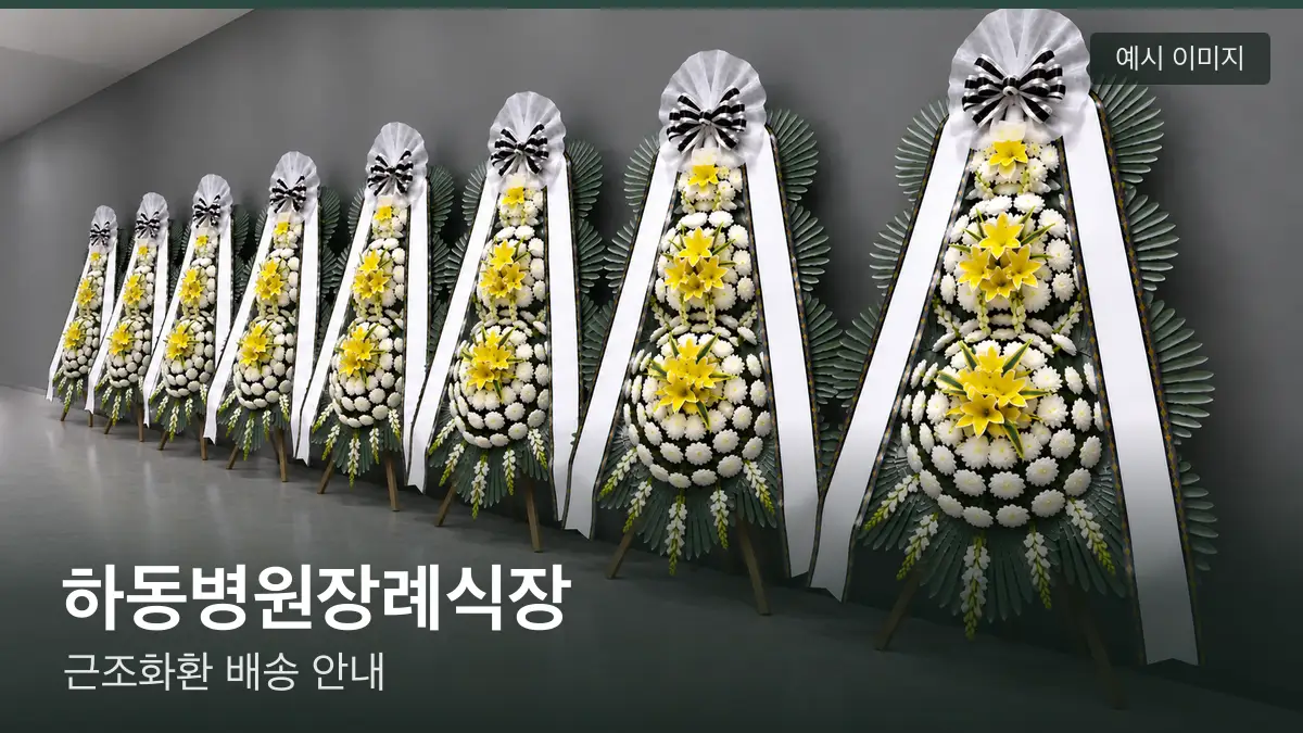 하동병원장례식장 근조화환 예시 이미지 — 흰 국화 3단 근조화환이 벽을 따라 나란히 놓인 모습