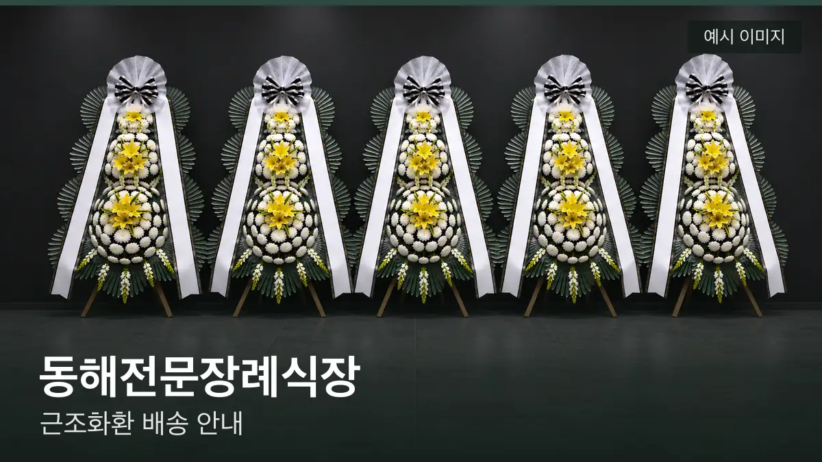 동해전문장례식장 근조화환 예시 이미지 — 흰 국화 3단 근조화환이 벽을 따라 나란히 놓인 모습