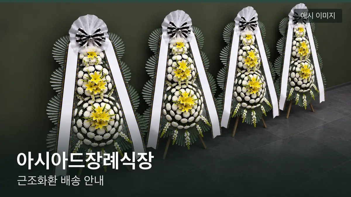 아시아드장례식장 근조화환 예시 이미지 — 흰 국화 3단 근조화환이 벽을 따라 나란히 놓인 모습