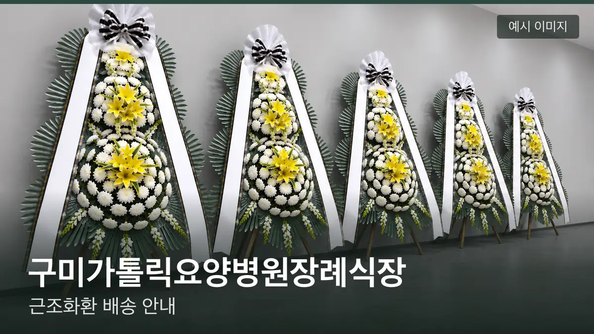 구미가톨릭요양병원장례식장 근조화환 예시 이미지 — 흰 국화 3단 근조화환이 벽을 따라 나란히 놓인 모습