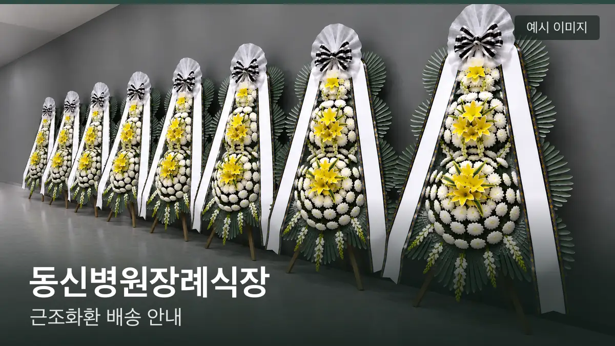 동신병원장례식장 근조화환 예시 이미지 — 흰 국화 3단 근조화환이 벽을 따라 나란히 놓인 모습