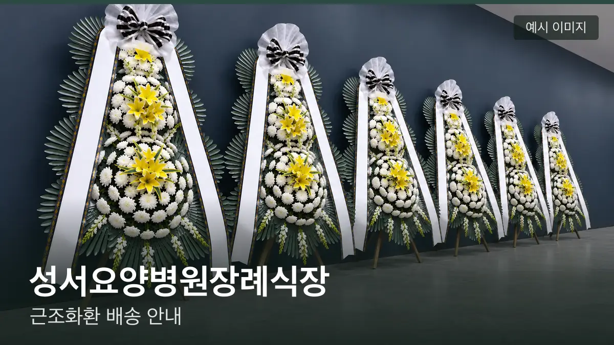 성서요양병원장례식장 근조화환 예시 이미지 — 흰 국화 3단 근조화환이 벽을 따라 나란히 놓인 모습