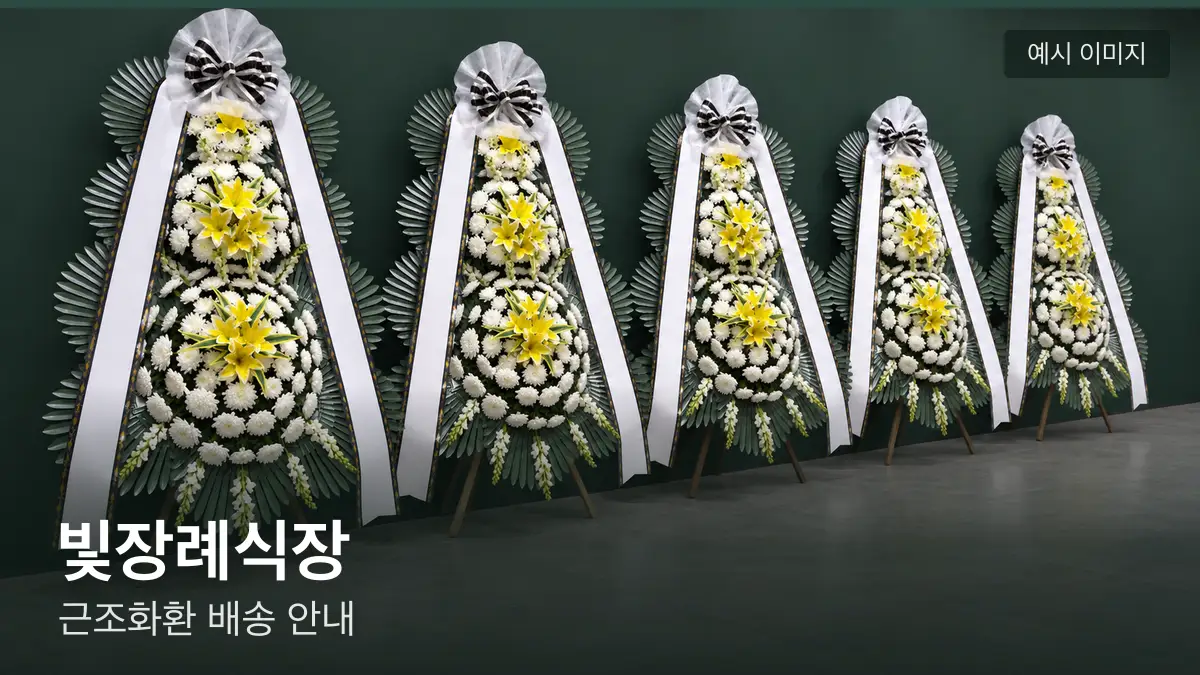 빛장례식장 근조화환 예시 이미지 — 흰 국화 3단 근조화환이 벽을 따라 나란히 놓인 모습