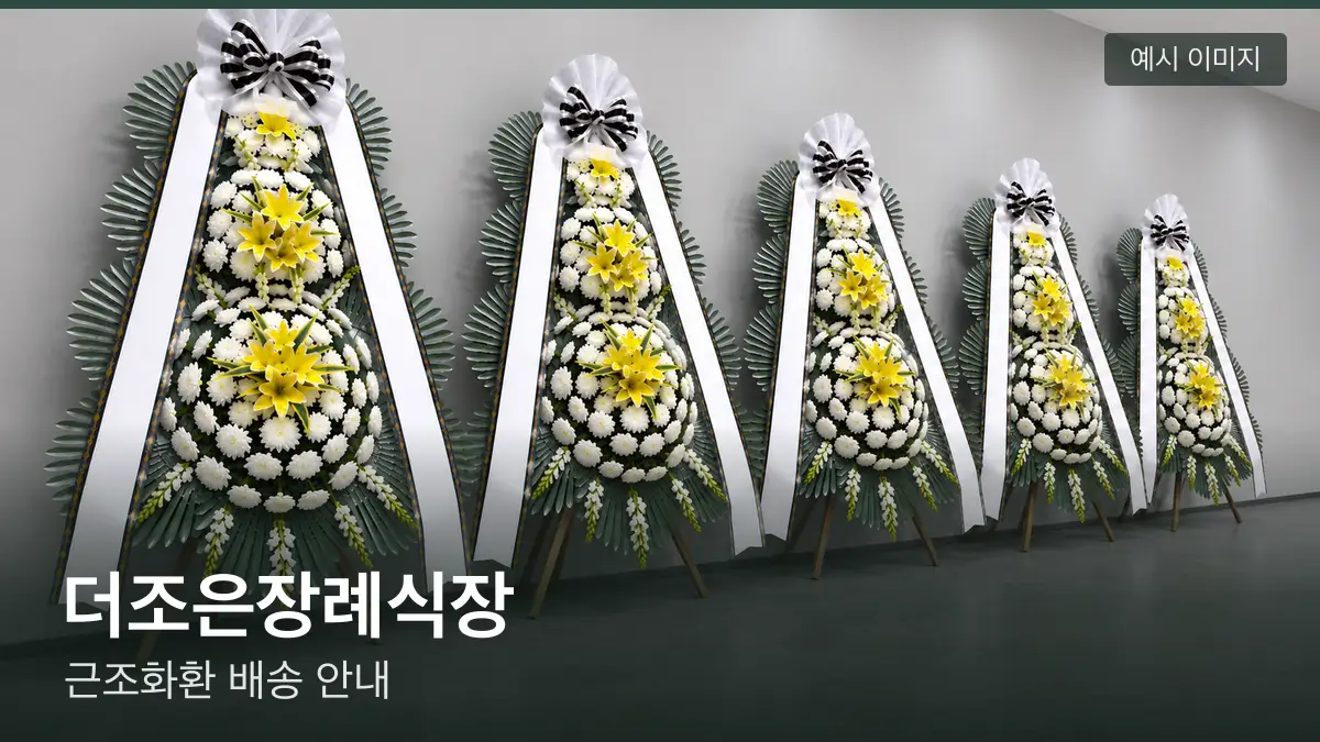 더조은장례식장 근조화환 예시 이미지 — 흰 국화 3단 근조화환이 벽을 따라 나란히 놓인 모습