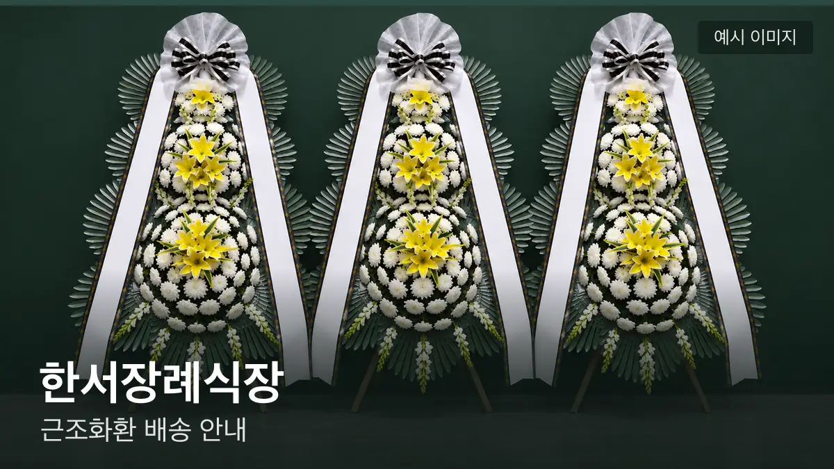 한서장례식장 근조화환 예시 이미지 — 흰 국화 3단 근조화환이 벽을 따라 나란히 놓인 모습