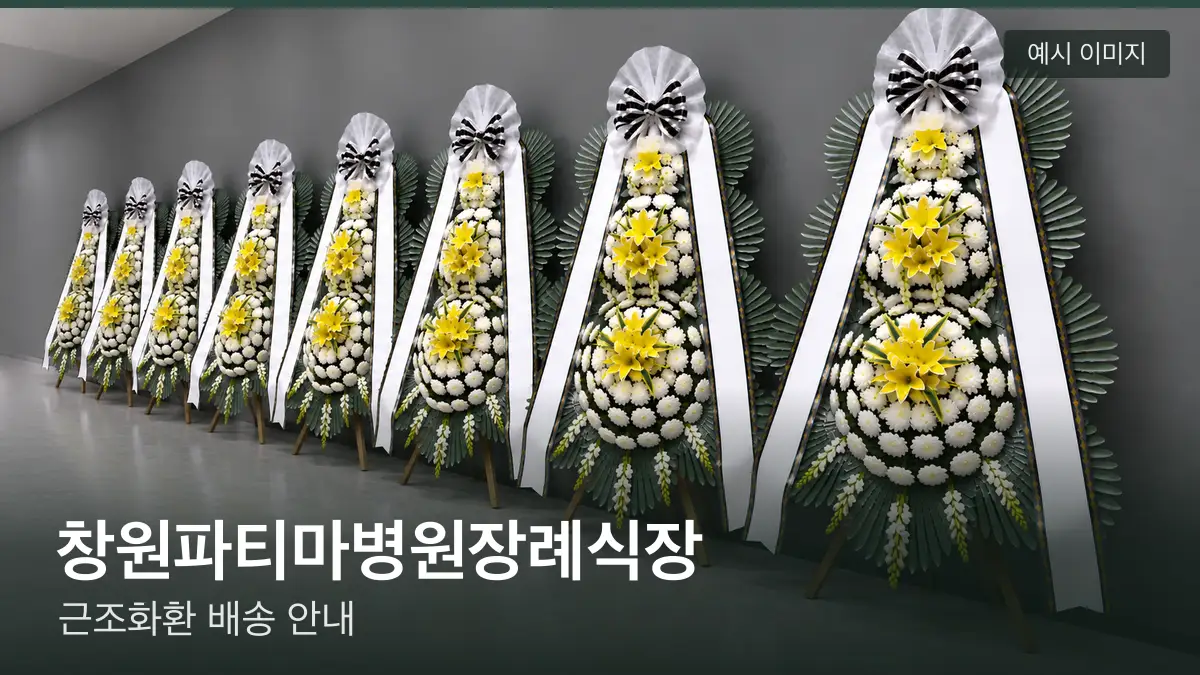 창원파티마병원장례식장 근조화환 예시 이미지 — 흰 국화 3단 근조화환이 벽을 따라 나란히 놓인 모습