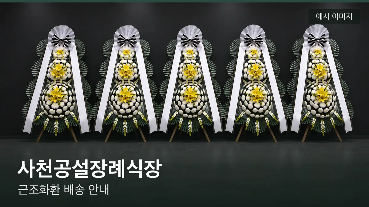 사천공설장례식장 근조화환 예시 이미지 — 흰 국화 3단 근조화환이 벽을 따라 나란히 놓인 모습