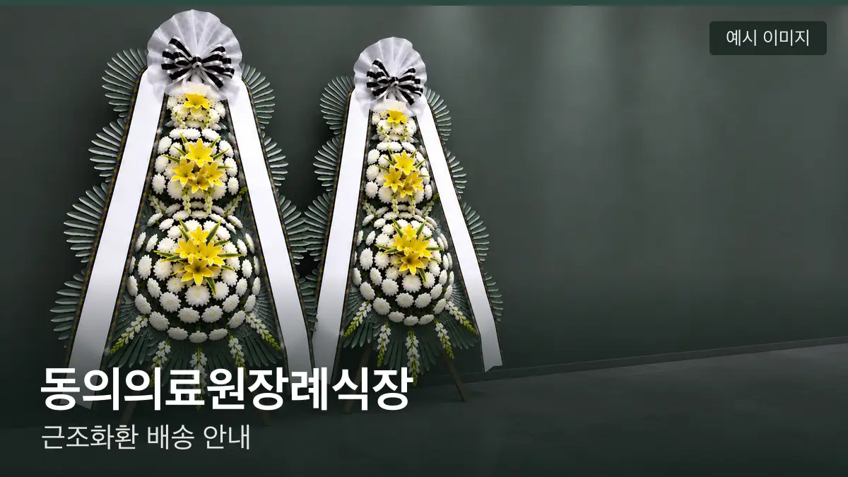 동의의료원장례식장 근조화환 예시 이미지 — 흰 국화 3단 근조화환이 벽을 따라 나란히 놓인 모습