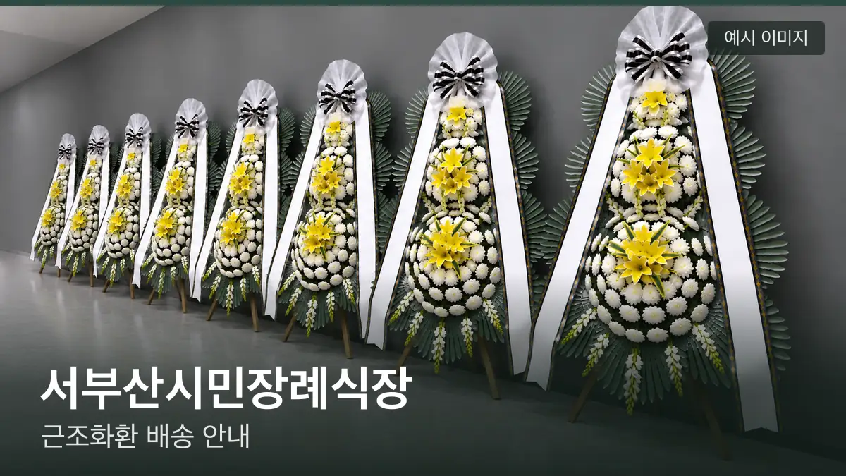 서부산시민장례식장 근조화환 예시 이미지 — 흰 국화 3단 근조화환이 벽을 따라 나란히 놓인 모습