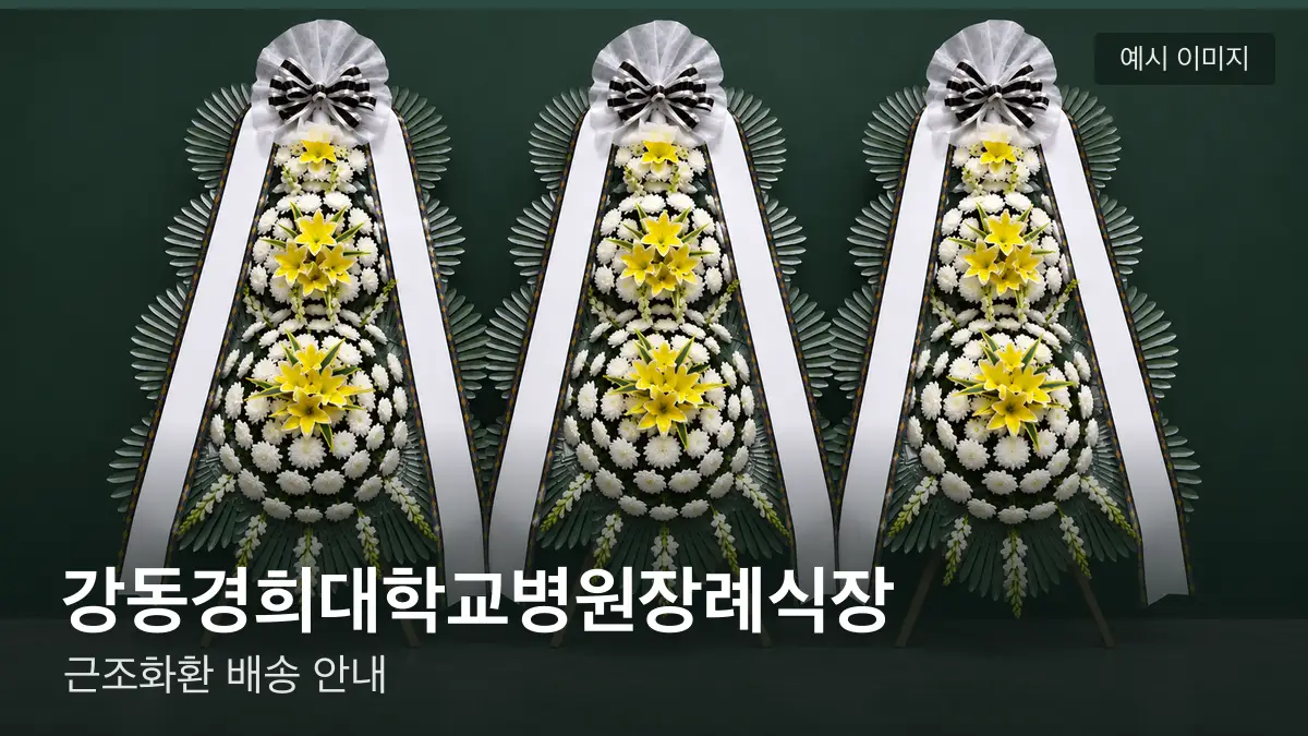 강동경희대학교병원장례식장 근조화환 예시 이미지 — 흰 국화 3단 근조화환이 벽을 따라 나란히 놓인 모습