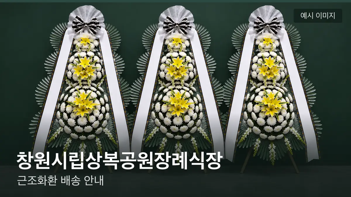 창원시립상복공원장례식장 근조화환 예시 이미지 — 흰 국화 3단 근조화환이 벽을 따라 나란히 놓인 모습