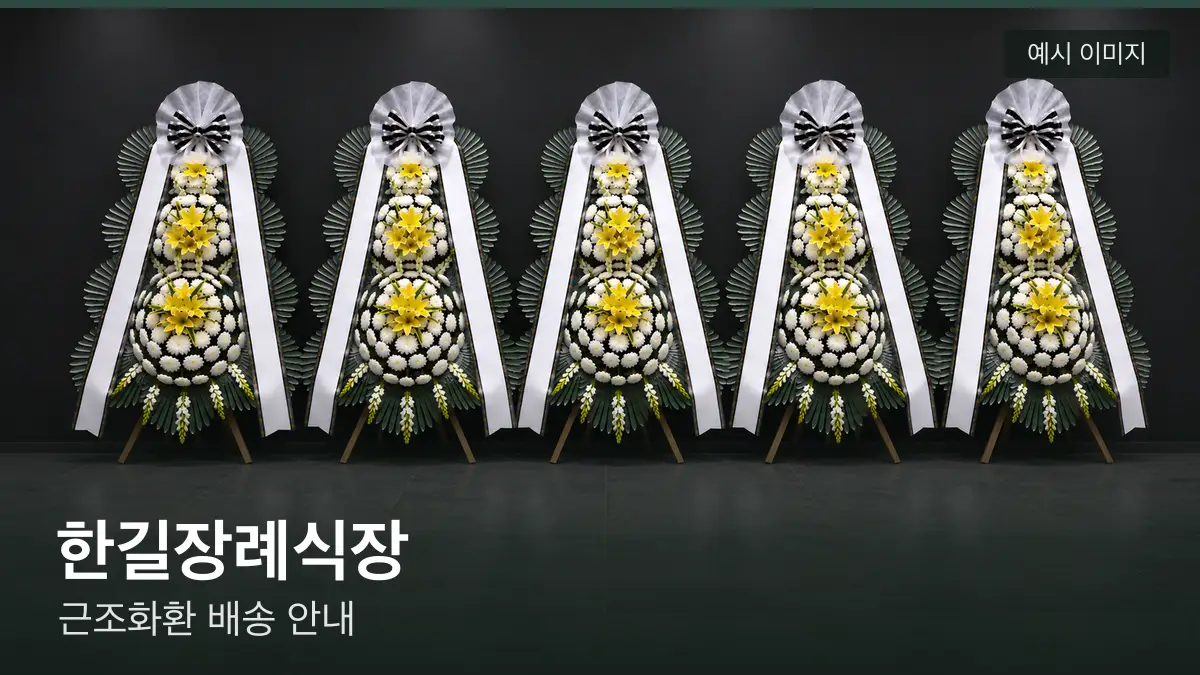 한길장례식장 근조화환 예시 이미지 — 흰 국화 3단 근조화환이 벽을 따라 나란히 놓인 모습