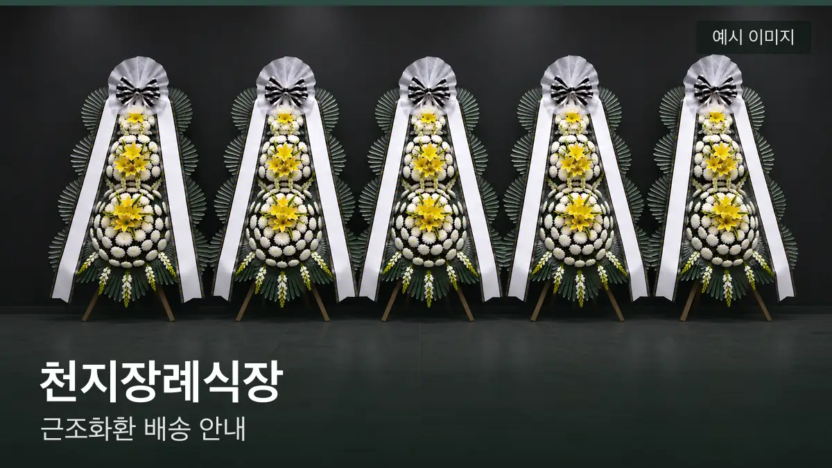 천지장례식장 근조화환 예시 이미지 — 흰 국화 3단 근조화환이 벽을 따라 나란히 놓인 모습