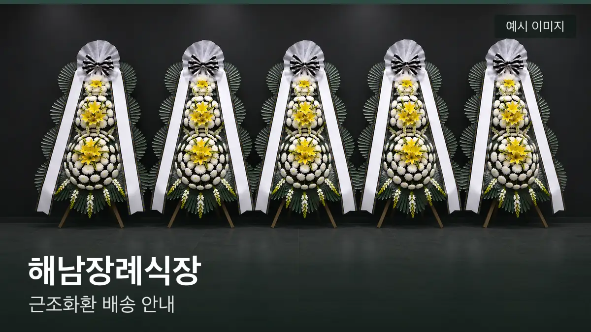 해남장례식장 근조화환 예시 이미지 — 흰 국화 3단 근조화환이 벽을 따라 나란히 놓인 모습