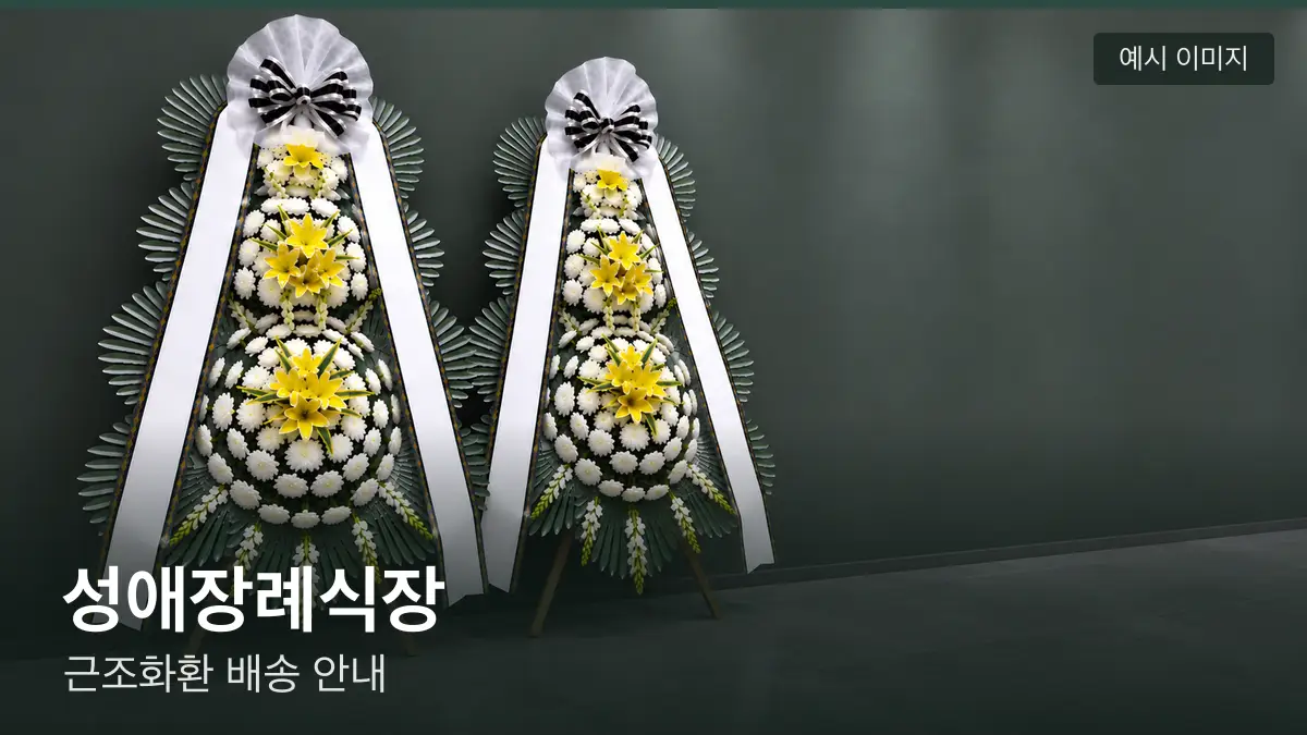 성애장례식장 근조화환 예시 이미지 — 흰 국화 3단 근조화환이 벽을 따라 나란히 놓인 모습