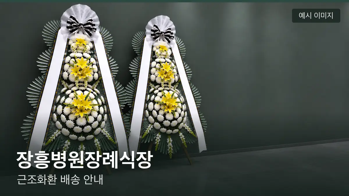 장흥병원장례식장 근조화환 예시 이미지 — 흰 국화 3단 근조화환이 벽을 따라 나란히 놓인 모습
